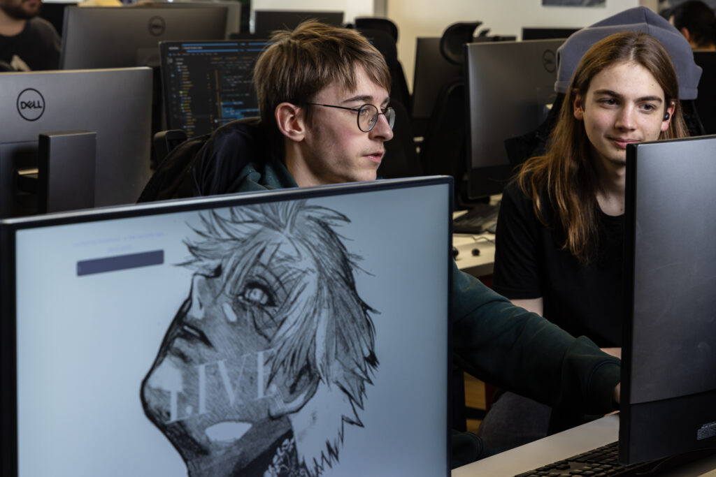 Deux étudiants qui se montrent du code pour réfléchir ensemble